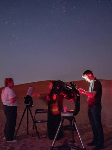 Astronomers with telescopes under the stars